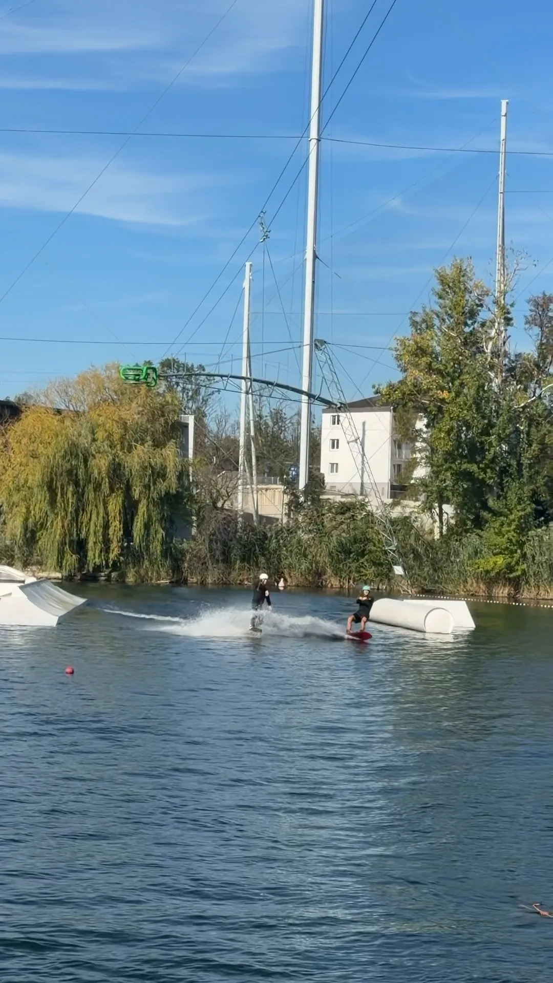 Zwei Wakeboarder im Cable-Park an einem sonnigen Herbsttag