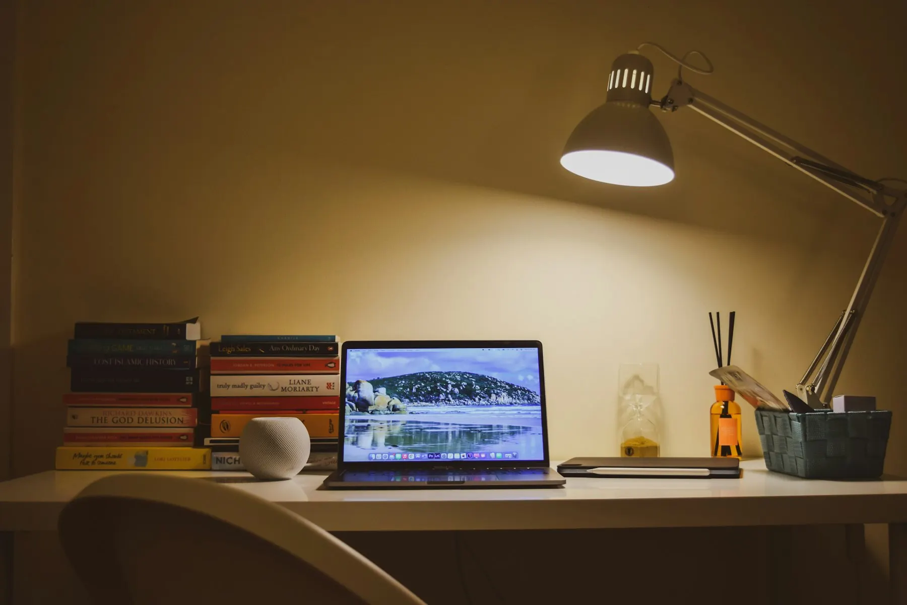 Schreibtisch am Abend mit Laptop unter einer Lampe